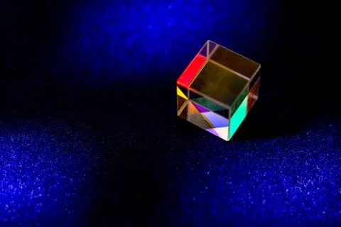 Colored square crystal with a rainbow on a substrate in close-up Stock Photos