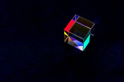 Colored square crystal with a rainbow on a substrate in close-up Stock Photos