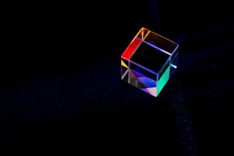 Colored square crystal with a rainbow on a substrate in close-up Stock Photos