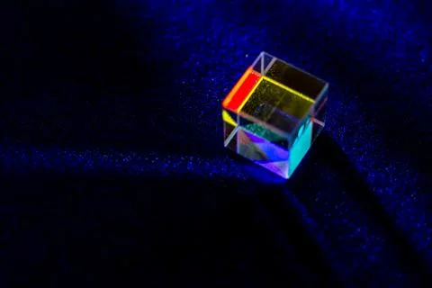 Colored square crystal with a rainbow on a substrate in close-up Stock Photos