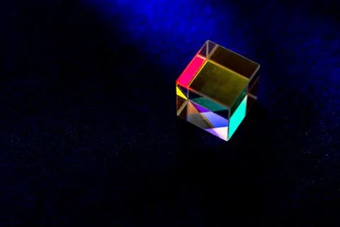 Colored square crystal with a rainbow on a substrate in close-up Stock Photos