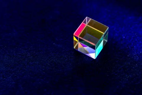 Colored square crystal with a rainbow on a substrate in close-up Stock Photos
