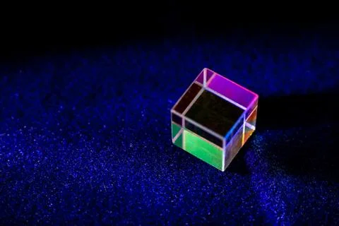 Colored square crystal with a rainbow on a substrate in close-up Stock Photos