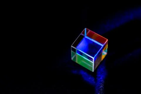Colored square crystal with a rainbow on a substrate in close-up Stock Photos