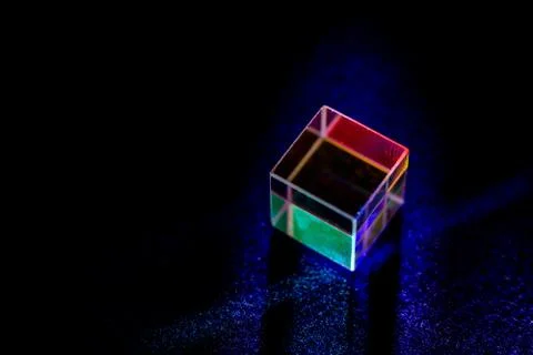 Colored square crystal with a rainbow on a substrate in close-up Stock Photos