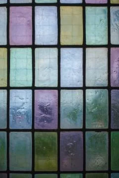Colored stained glass window with regular block pattern blue green tone Stock Photos