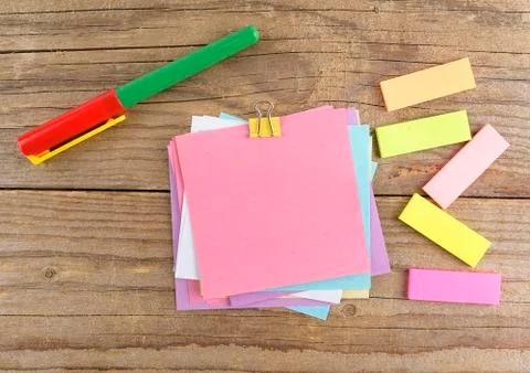 Colored stickers around notebook on old wooden table Stock Photos