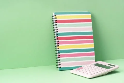 Colored stripes notepad and calculator on green. Back to School Stock Photos