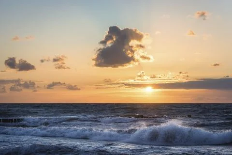 Colored sunset with cloud cover over the sunset at the beach, dramatic sunset on Stock Photos