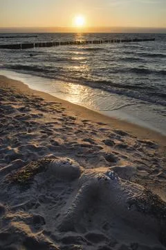 Colored sunset with cloud cover over the sunset at the beach, dramatic sunset on Stock Photos