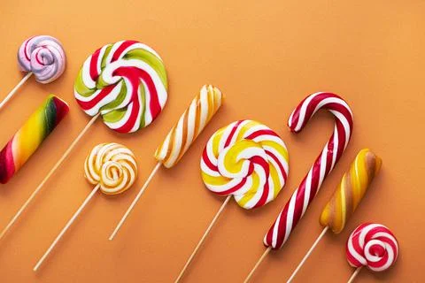 Colored sweet lollypops on orange Stock Photos