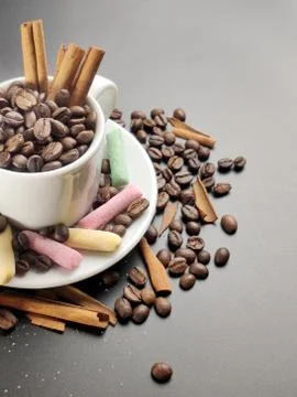 Colored sweets and a Cup with coffee beans on a black background Stock Photos