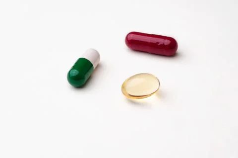 Colored tablets and capsules on white background Stock Photos