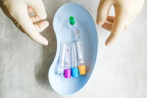 Colored test tubes are in a container. View from above. Hands with gloves Stock Photos