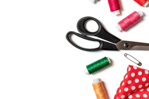 Colored thread coils, scissors, pin and fabric on white background, sewing, h Stock Photos