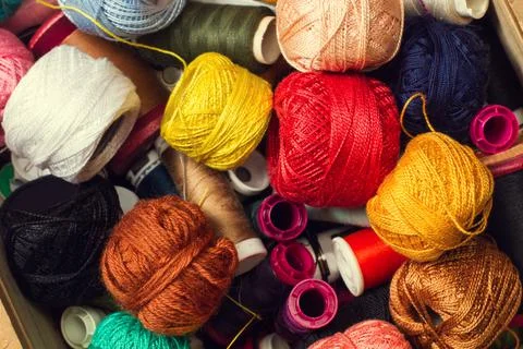 Colored thread spools and yarn balls in a close up view Stock Photos