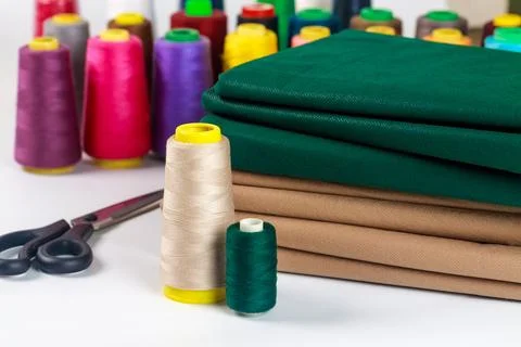 Colored thread spools whit fabric for sewing machine. Stock Photos