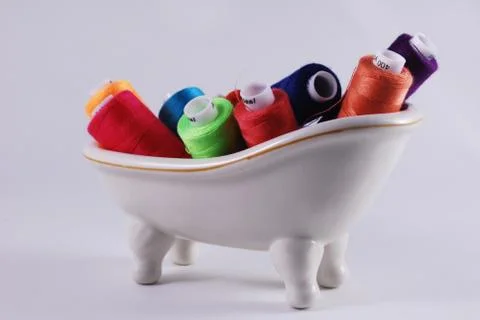 Colored threads in a white bath Stock Photos