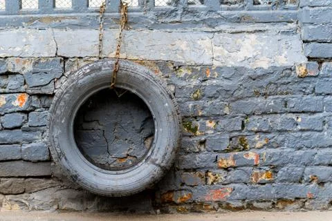 Colored tires hanging on the chain have a brick wall Stock Photos
