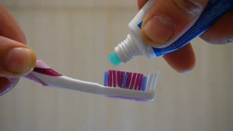 Colored toothbrush and turquoise toothpaste 4K Video stock 147894687