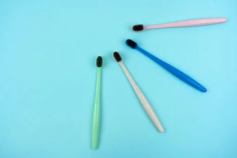 Colored toothbrushes made from recycled plastic on a light blue background Stock Photos