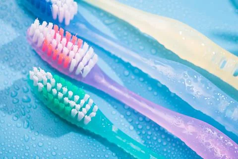 Colored toothbrushs with water drops Stock Photos