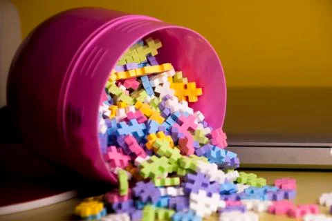 Colored toy constructions that come out of a container Stock Photos