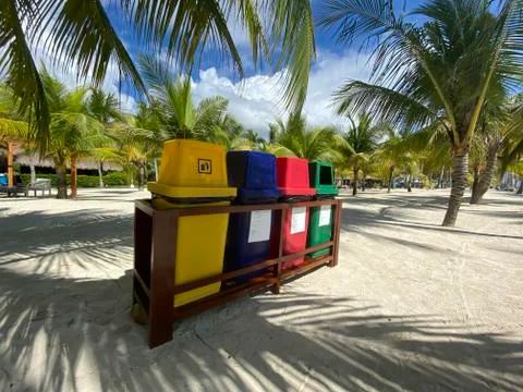 Colored trash cans, container on a white sandy beach. Ecological, waste dispo Stock Photos