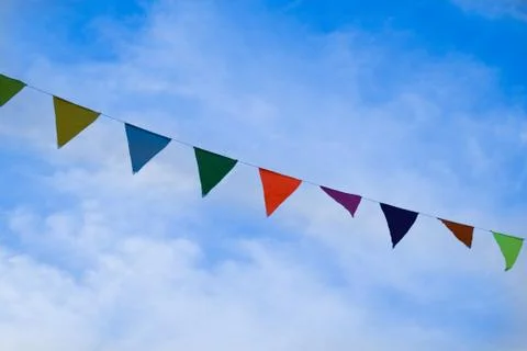 Colored triangular flags on bright blue sky background Stock Photos