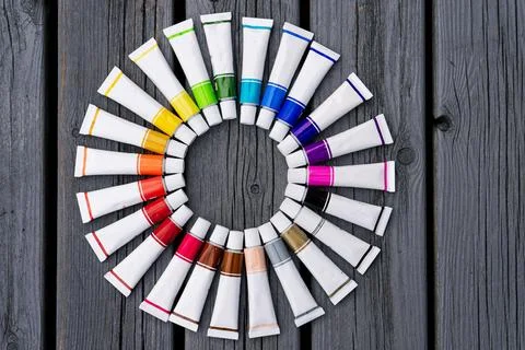 Colored tubes of paint in shape of circle on wooden background top view 스톡 사진