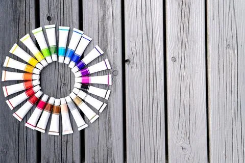 Colored tubes of paint in shape of circle on wooden background top view 스톡 사진