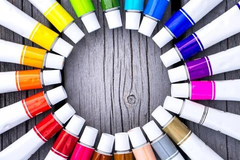 Colored tubes of paint in shape of circle on wooden background top view 库存照片