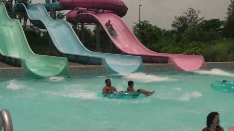 Colored Waterslides Splash Ending in Swimming Pool Stock Footage 31947657