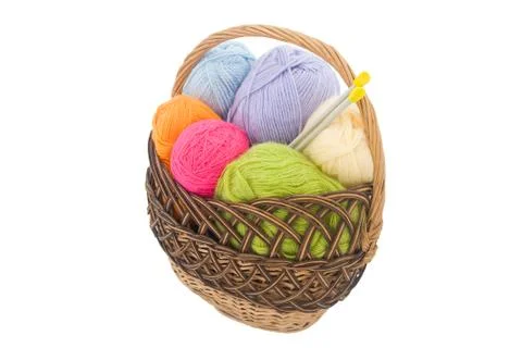 Colored wool clews with needles in wicker basket, white background Stock Photos