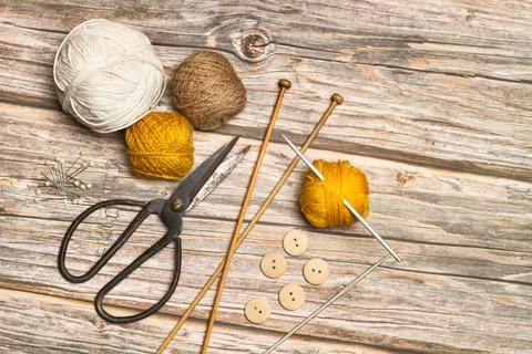 Colored wool spools and crochet hooks on a wooden background with copy space Foto stock