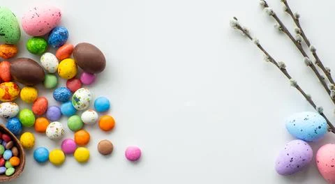 Colorful and chocolate easter eggs with sweet dragee on white background Stock Photos