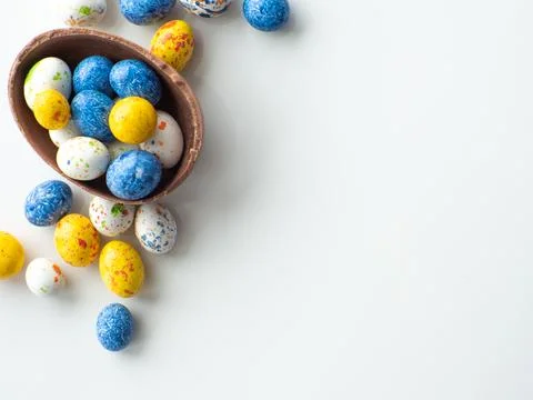 Colorful and chocolate easter eggs with sweet dragee on white background Stock Photos