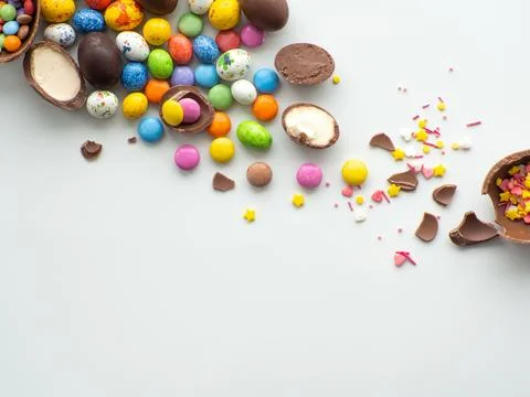 Colorful and chocolate easter eggs with sweet dragee on white background Stock Photos