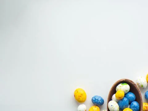 Colorful and chocolate easter eggs with sweet dragee on white background Stock Photos