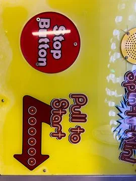 Colorful arcade panel featuring stop button and pull to start instructions Stock Photos