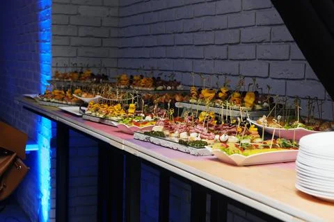 Colorful array of appetizers displayed on a table in a vibrant event room Stock Photos