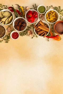 A colorful array of dried spices and fresh herbs arranged on a soft beige b.. Stock Photos