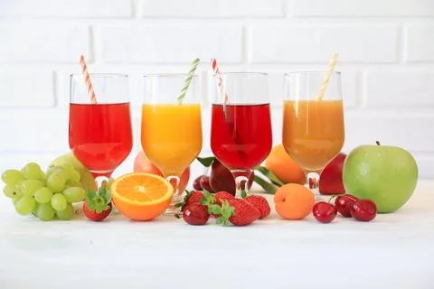 Colorful array of fresh fruit juices displayed in glasses on white background Stock Photos