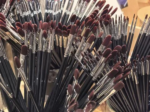 Colorful array of paintbrushes displayed in an artistic studio setting Stock Photos