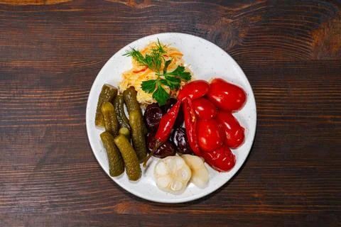 Colorful array of pickled vegetables served on a white plate Stock Photos