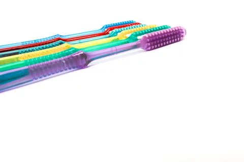 A colorful array of toothbrushes lined up on a white background, showcasing.. Stock Photos