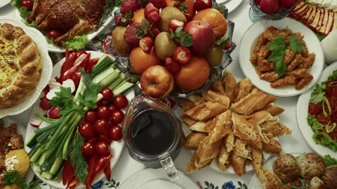 Colorful array of traditional dishes and fresh fruits displayed on a festive Stock Footage 332736935