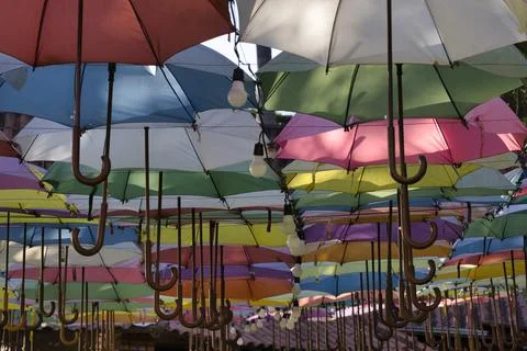A colorful array of umbrellas hanging from the ceiling Stock Photos