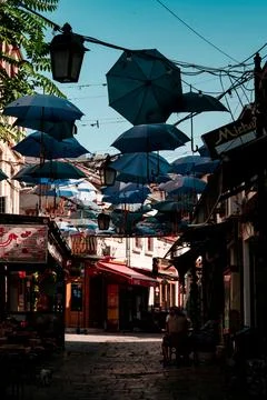 Colorful array of umbrellas suspended above tables of a cafe in Skopje 写真素材