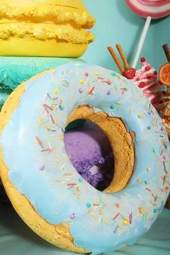 Colorful artificial sweets including a large donut with blue icing and sprinkles Stock Photos
